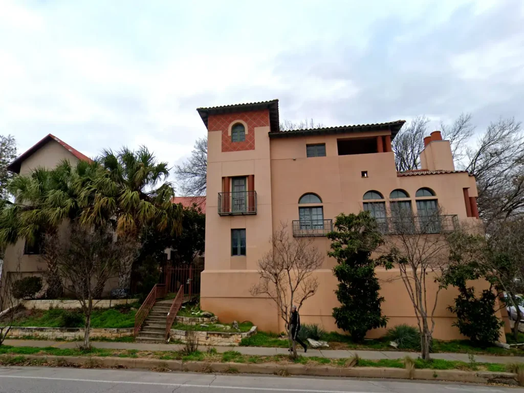 600-harthan-screenshot-2026-07-13-at-3-37-06-pm-web Historic multifamily building exterior with red clay tile roof and arched windows, 600 Harthan Street hotel conversion