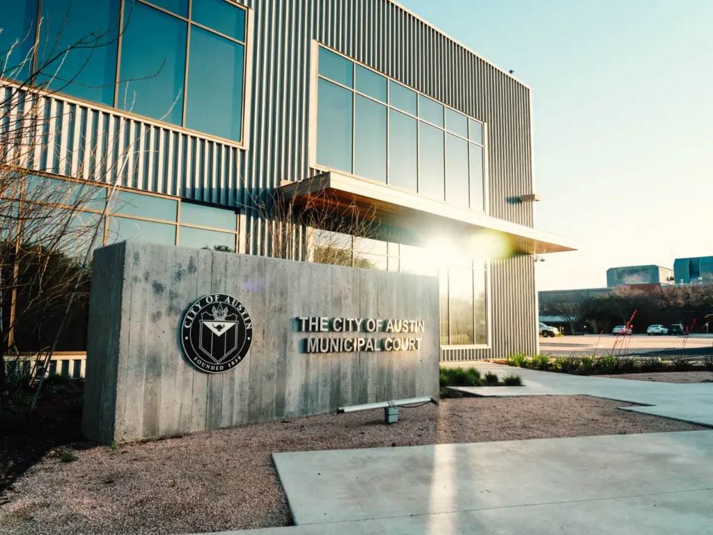 Home 7 City of Austin Municipal Court, civic development, Austin TX — exterior entrance and signage at golden hour