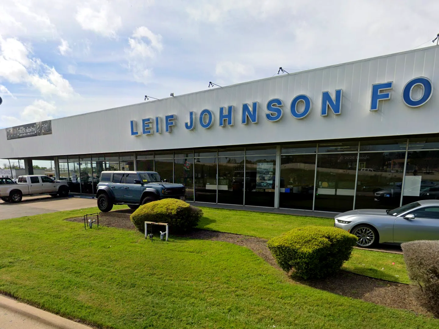 Leif Johnson Ford dealership in Austin, Texas, with the glass showroom storefront and landscaped frontage along the street
